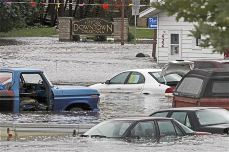 Floodwaters partially submerge vehicles in a used car lot in Owatonna, Minn. on Friday, Sept. 24, 2010. (AP Photo/The Star Tribune, Marlin Levison)